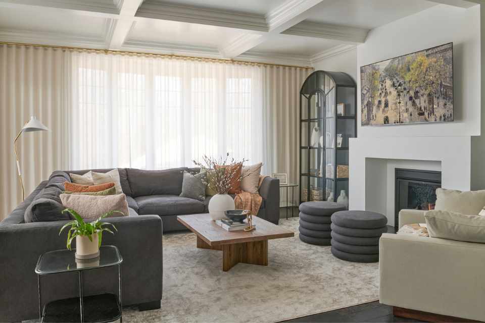 designer living room with earth toned decor and coiffured ceilings